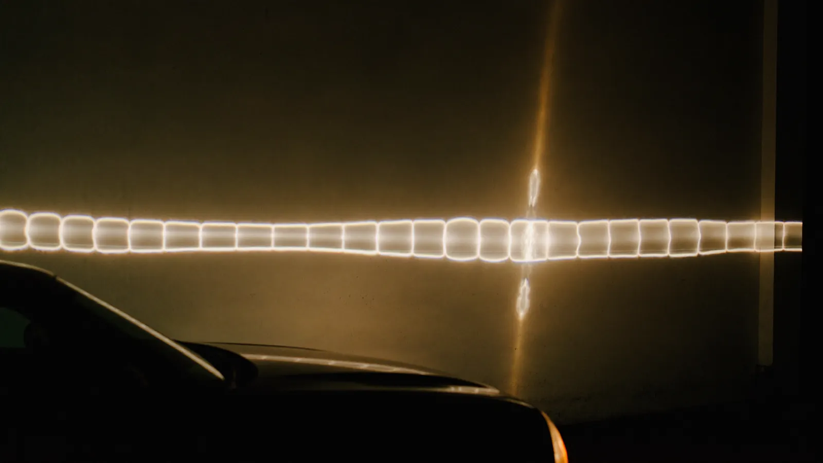 Headlamp beams on a workshop wall