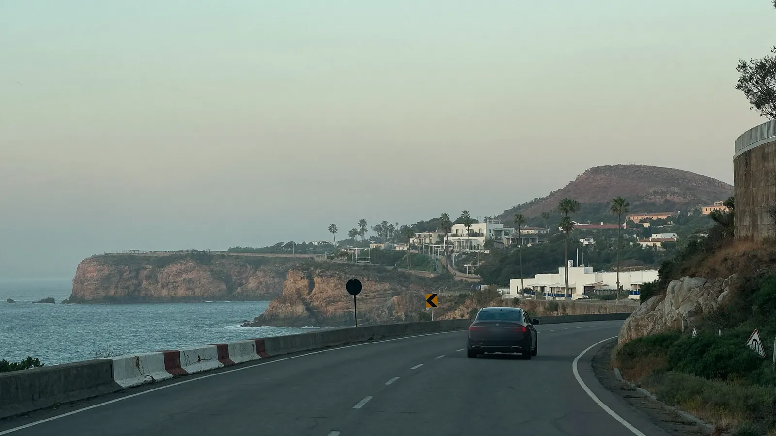 A single car on the coast road at first light