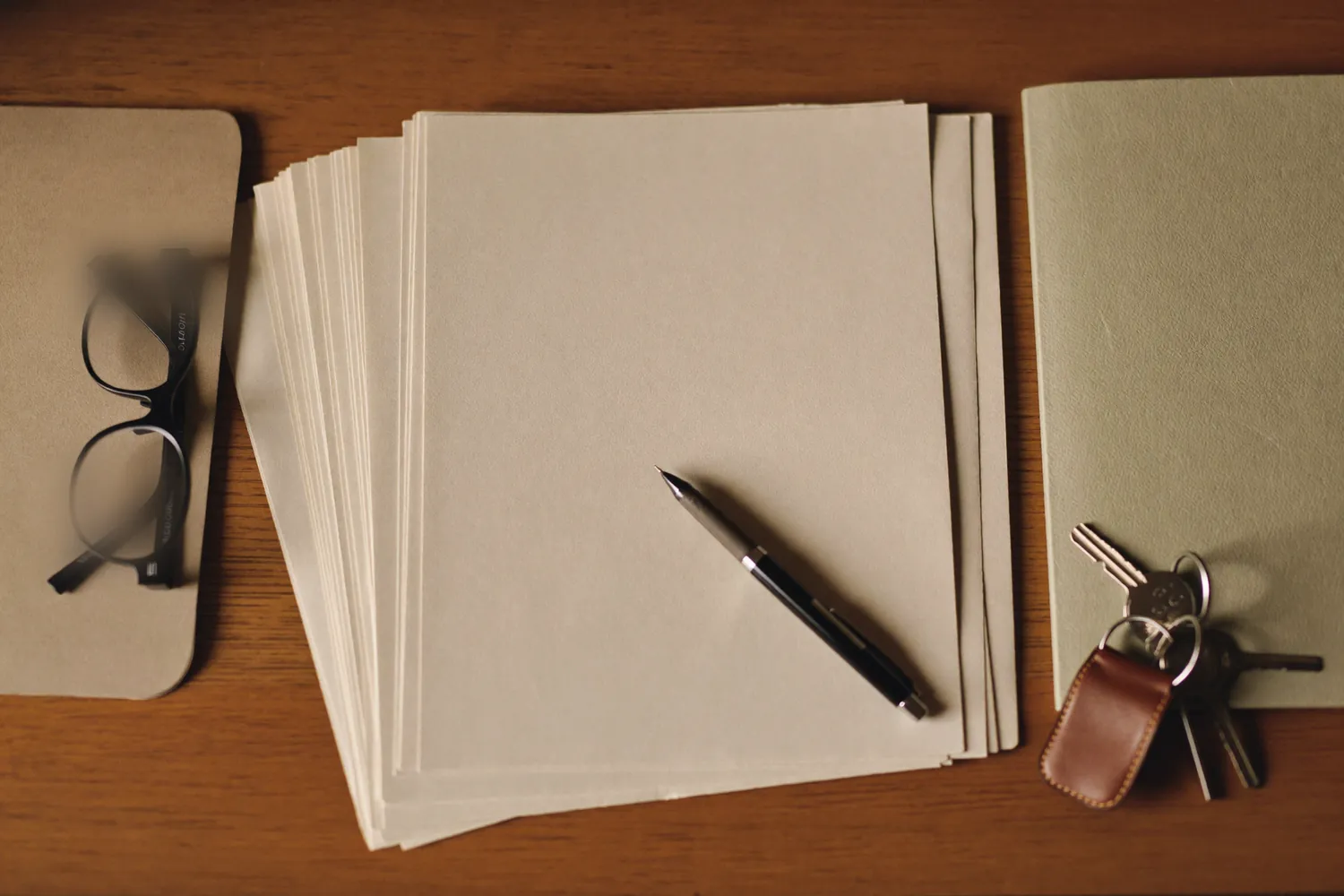Blank paperwork, a pen and car keys on a desk