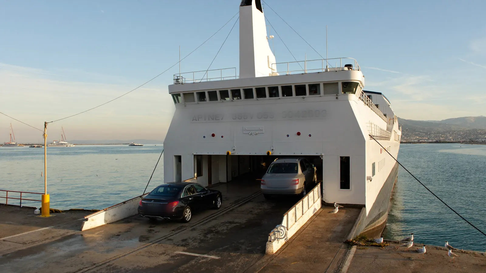 Cars driving off a ferry ramp onto a quayside